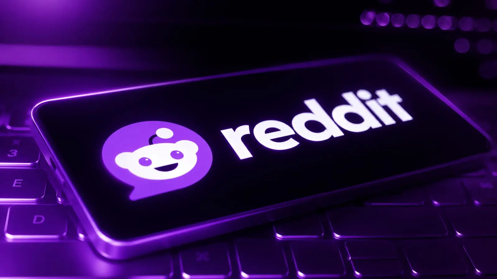 glowing purple Reddit logo on phone keyboard representing Indian creators using Reddit for growth 2026